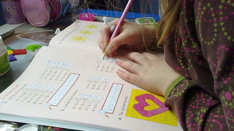 Koululainen tekee matematiikan tehtäviä.
