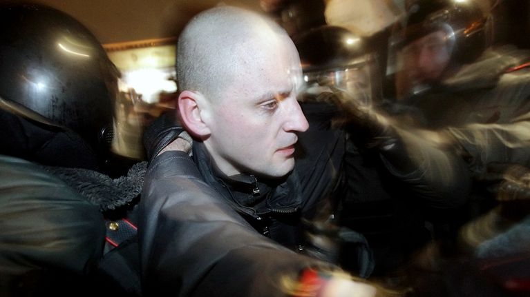 Venäläiset poliisit taluttavat oppositiojohtaja Sergei Udaltsovia Moskovassa.