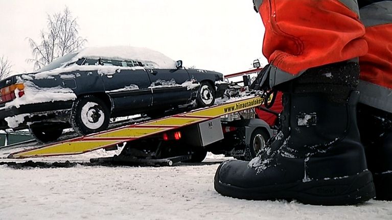 Henkilöautoa nostetaan hinausauton lavetille