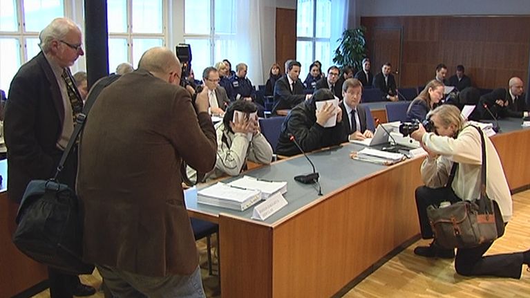 Syytetyt oikeuden pöydän ääressä.