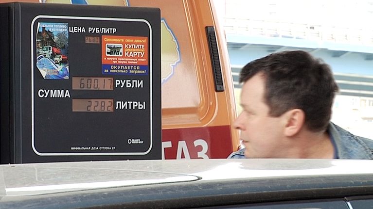 Mies tankkaa autoaan.