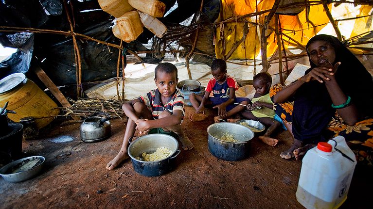 Somaliasta paennut nainen lapsineen itsetehdyssä kojussaan pakolaisleirillä.