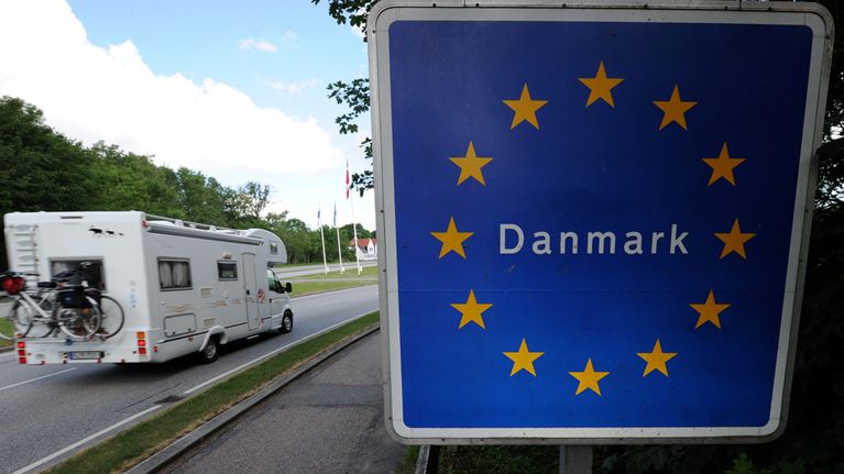 Tanskan Krusan ja Saksan Flensburgin välinen raja-alue. Taustalla asuntoauto ylittämässä rajaa.