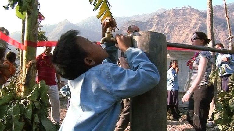 Nepalilaispoika juo kaivosta.