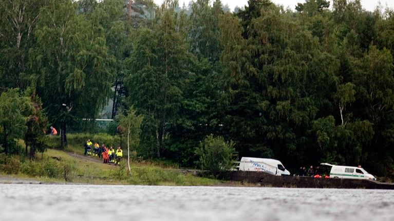 Pelastusmiehistön ja poliisin tutkimusryhmän jäseniä Utøyan saaren rannassa.