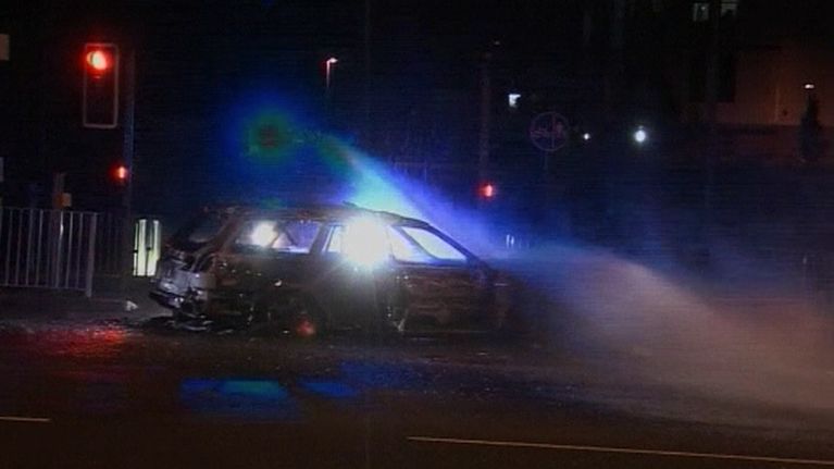 Palokunta sammuttaa mellakoitsijoiden polttamaa autoa tiistain ja keskiviikon välisenä yönä West Bromwichissa Britanniassa.