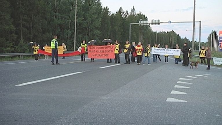 Mielenosoittajia tiellä.