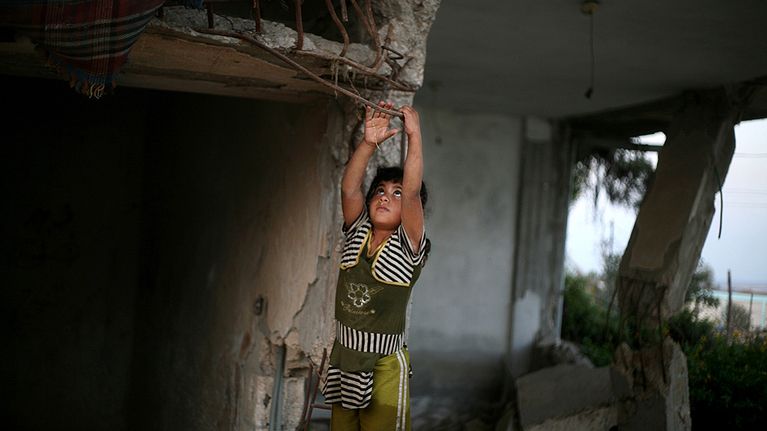Palestiinalaistyttö leikkii perheensä Gazan sodassa tuhoutuneen kodin jäännöksissä.