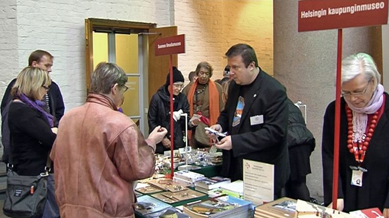 ihmiset ostoksilla myyjäipöytien ääressä