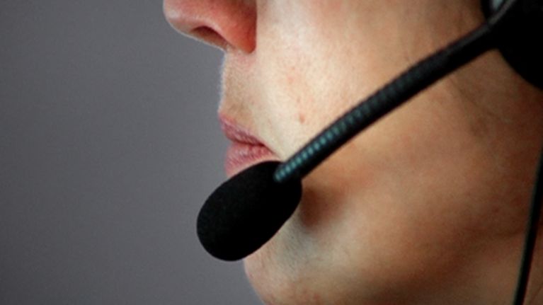 Kuvassa on puhelinneuvoja handsfree-kuuloke korvallaan.