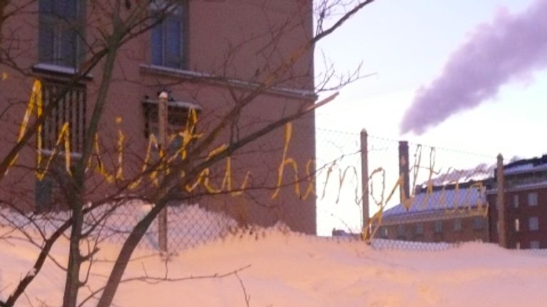 Muista hengittää -teksti aidassa, taustalla savupiippu ja vesihöyryä