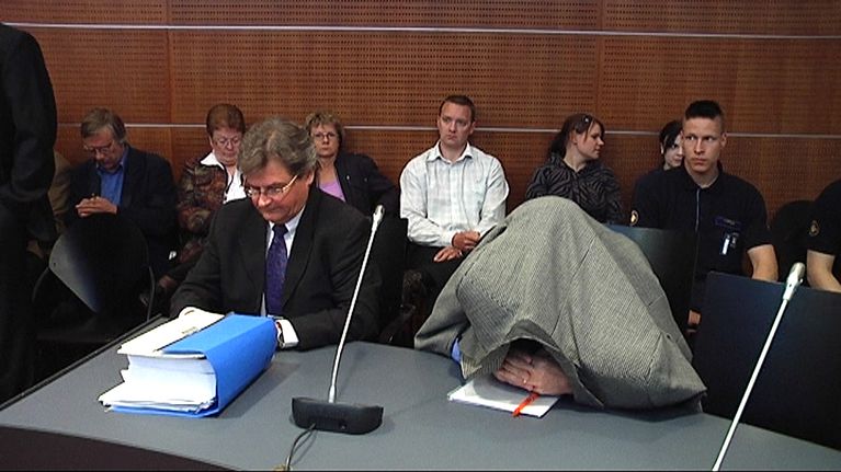 Kuvassa syytetyn virkamiehen asianajaja ja syytetty.