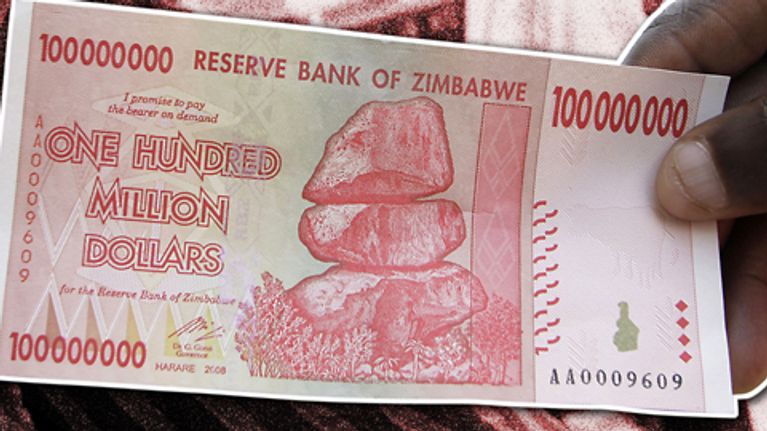 Miehen kädessä on Zimbabwen 100 miljoonan dollarin seteli.