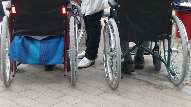 Kuvassa pyörätuoleissa olevia vanhuksia ulkoilutapahtumassa. 