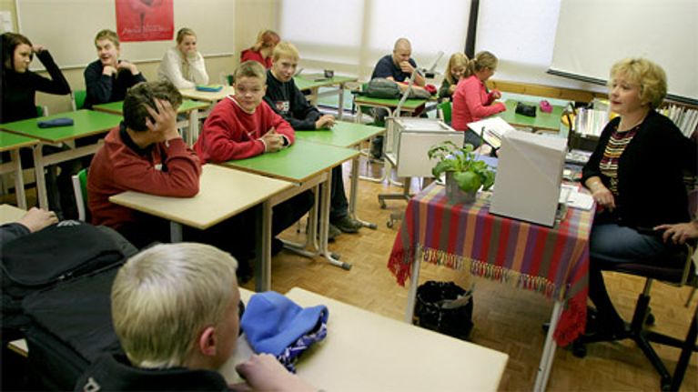 Koululaisia opettajan kanssa luokassa
