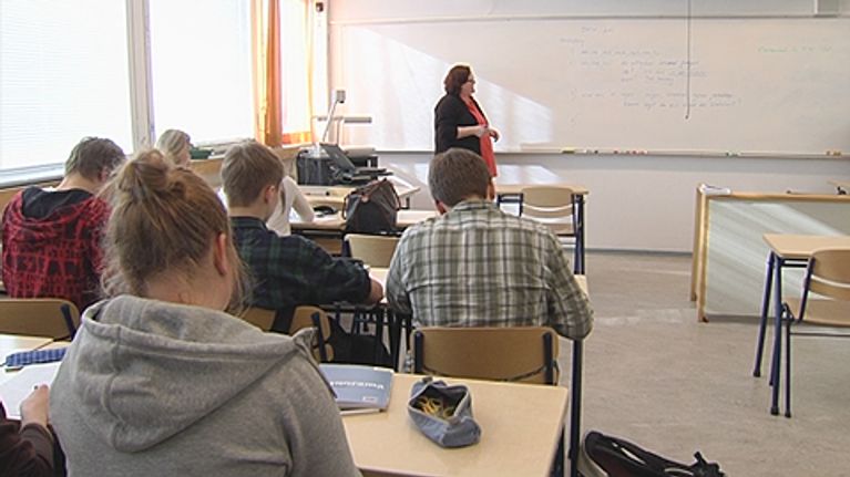 Opettaja ja oppilaita luokkahuoneessa.