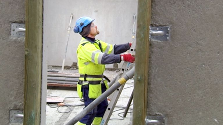 Mies työskentelee rakennustyömaalla.