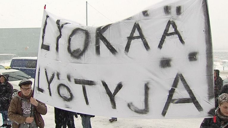 Mielenosoittajat pitelevät banderollia.