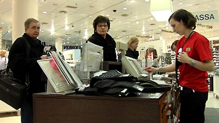 Ihmiset maksavat jouluostoksia tavaratalon kassalla.