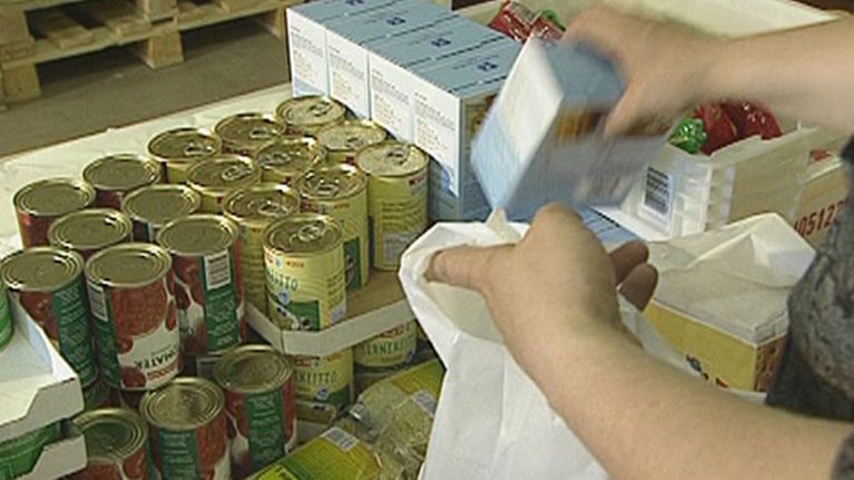 Seurakunnan työntekijä pakkaa ruoka-apukassia.