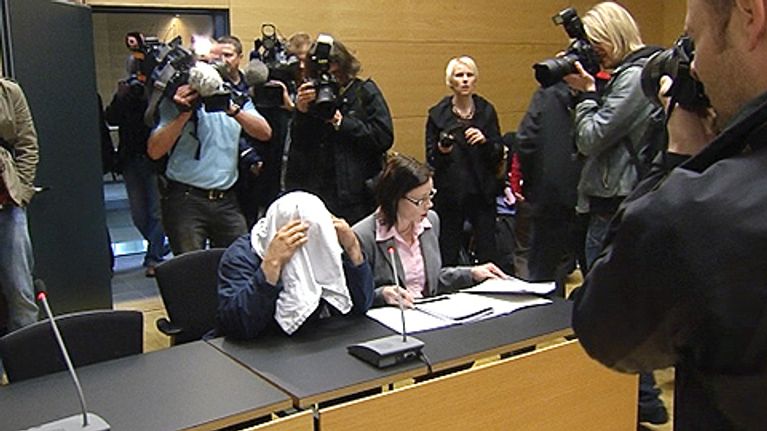 Epäilty asianajajineen oikeussalissa