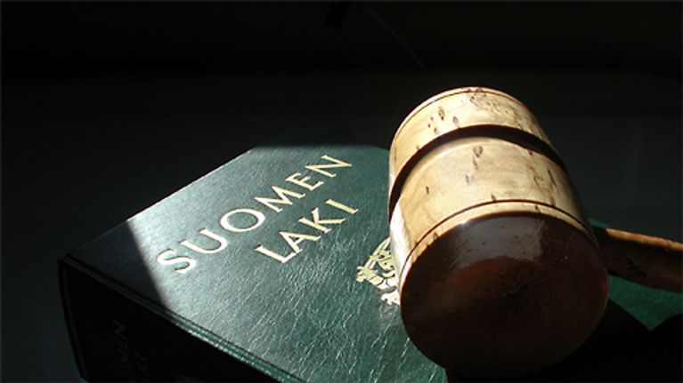 Kuvassa lakikirja ja tuomarin nuija