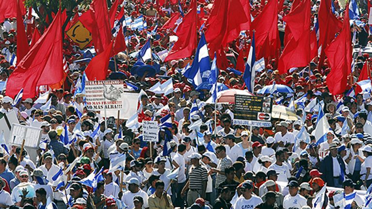 Hallitusta vastustavat mielenosoittajat Nicaraguan pääkaupungissa Managuassa. Kuljettavat punaisia lippuja ja kylttejä.