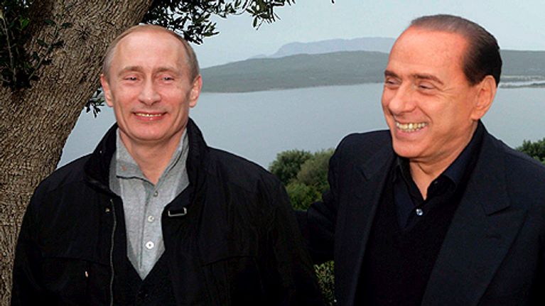 Venäjän pääministeri Vladimir Putin ja Italian pääministeri Silvio Berlusconi hymyilevät vierekkän. Taustalla Italian järvimaisemaa.