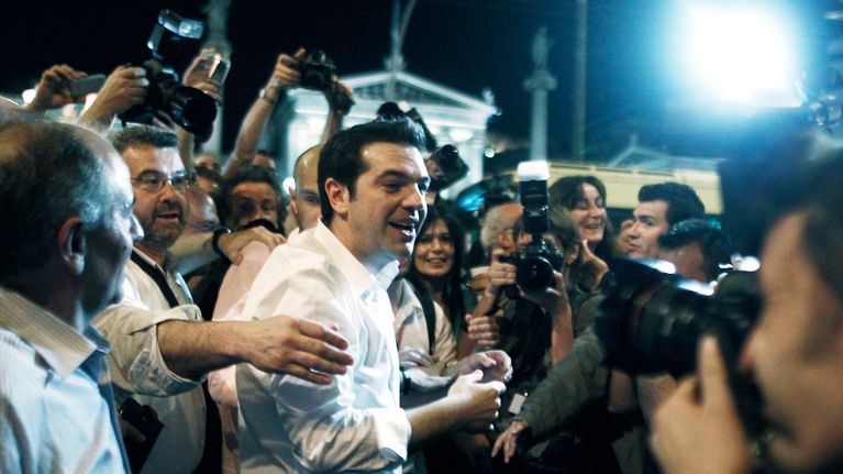 Alexis Tsipras kuvaajien ympäröimänä.