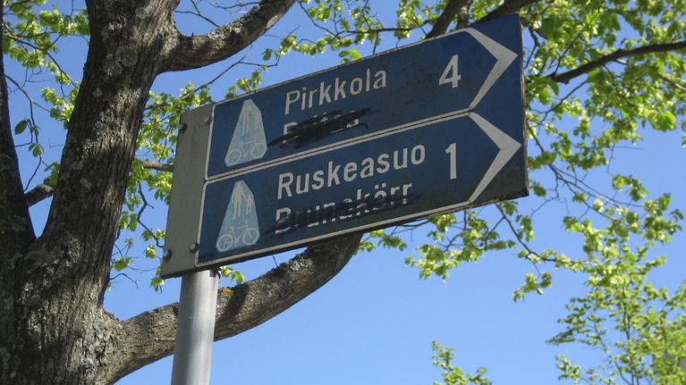 Opasteviitoista on töhritty peittoon ruotsinkieliset nimet.