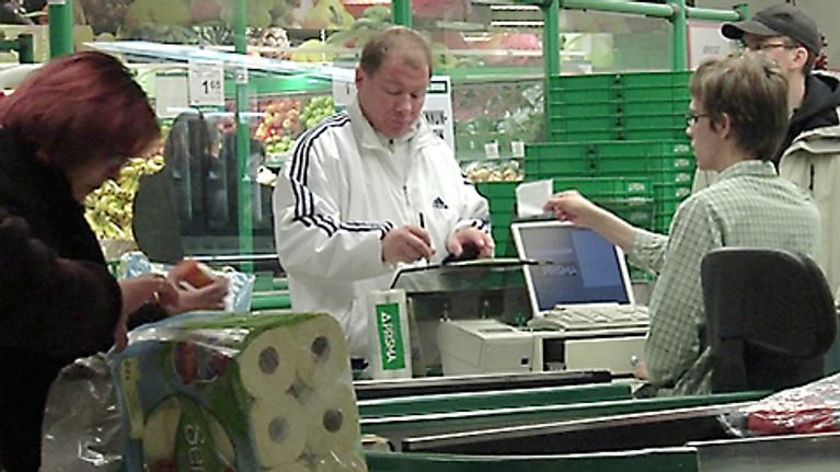 Ihmisiä kaupan kassalla