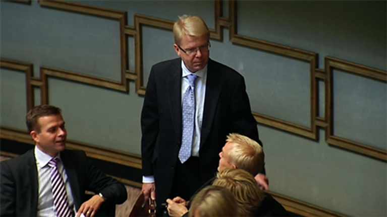 Puolustusministeri Jyri Häkämies jututtaa kansanedustajia Eduskuntatalon istuntosalissa.