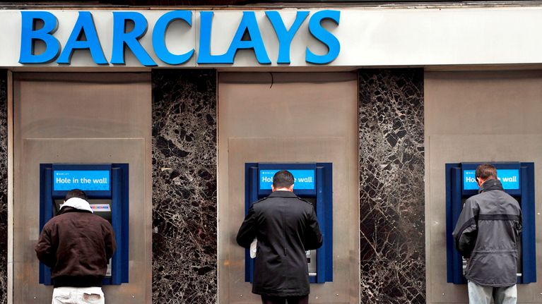Miehiä nostamassa rahaa Barclays-pankin automaateilta.