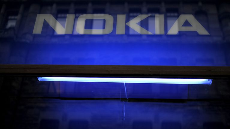 Nokian logon päällä näkyvät ympäröivät heijastukset kadulla.