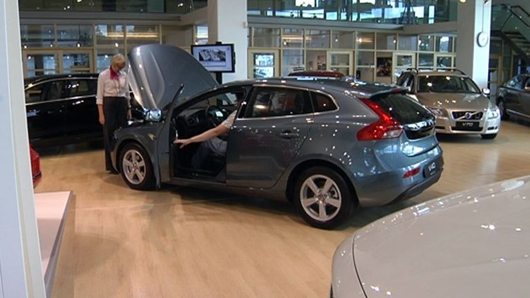 Asiakkaita autoliikkeessä.