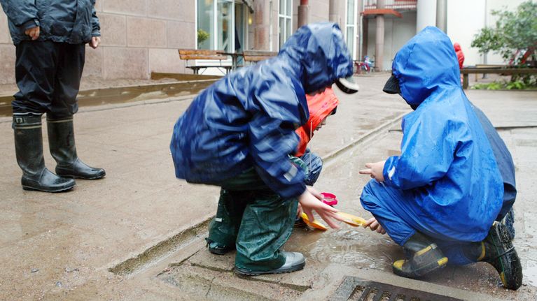 Sadeasuiset lapset leikkivät päiväkodin pihalla.