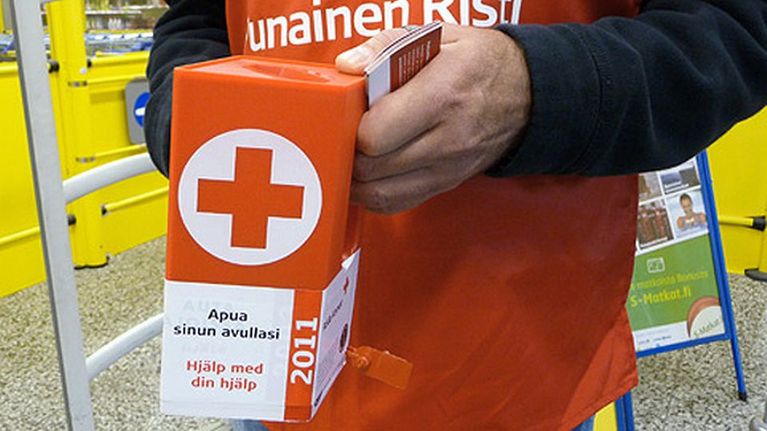 Nälkäpäivä-kerääjä lippaan kanssa.