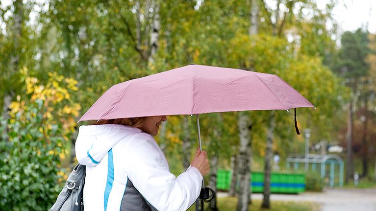 Nainen sateenvarjon alla.