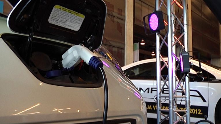Sähköauto kiinnitettynä latauspistokkeeseen.