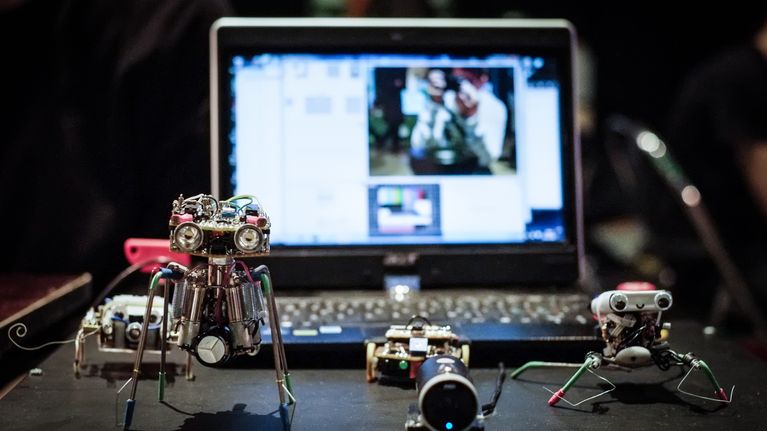 Neljä pientä söpöä robottia pöydällä.