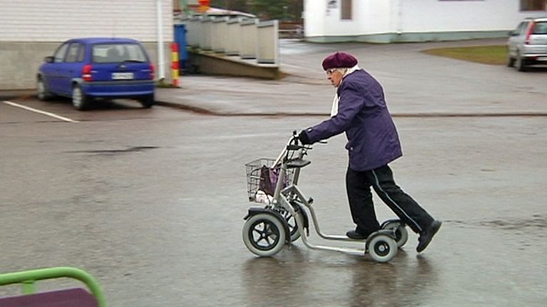 Vanhus kadulla rollaattorin kanssa.