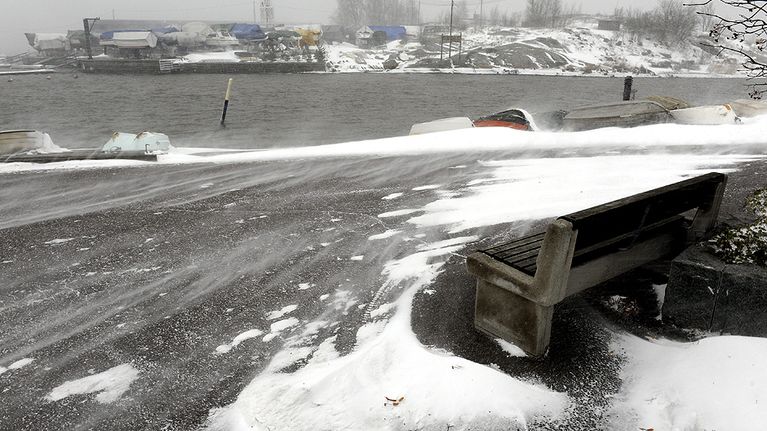 Lumi pöllyää tuulessa Kaivopuiston rannassa Helsingissä.