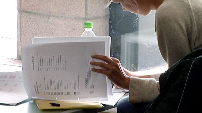 Opiskelija kirjoittaa muistiinpanoja Turun yliopistossa.