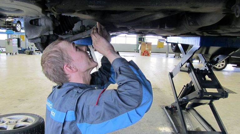 Jouko Ala-Pöntiö huoltaa autoa.