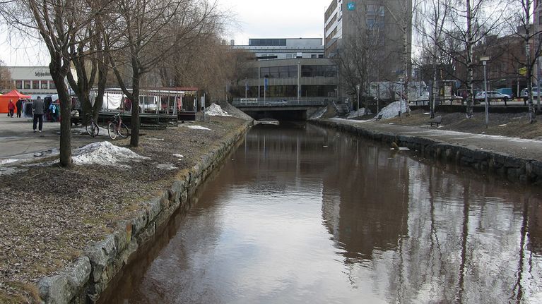 Kuvassa ruskeavetinen kaupunginsalmi ja keskustan rakennuksia Kokkolassa