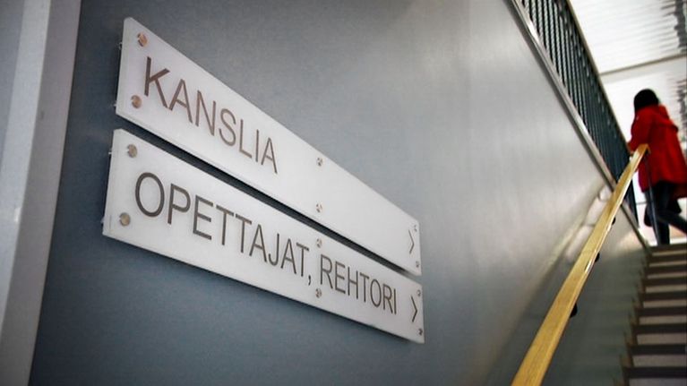 Kanslian ja opettajainhuoneen kyltti koulun käytävällä.