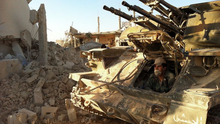 Syyrian armeijan sotilas istuu tankissa valloitetussa Qusairin kaupungissa.