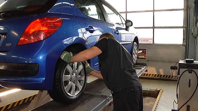 Katsastusmies katsastaa autoa.