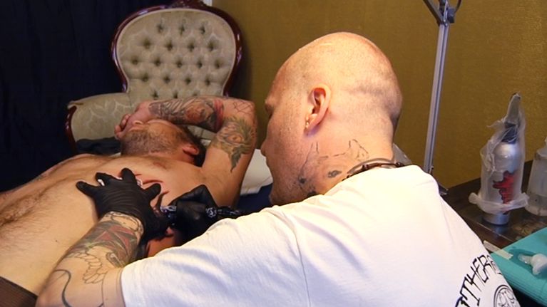 Asiakas tatuoijan luona.