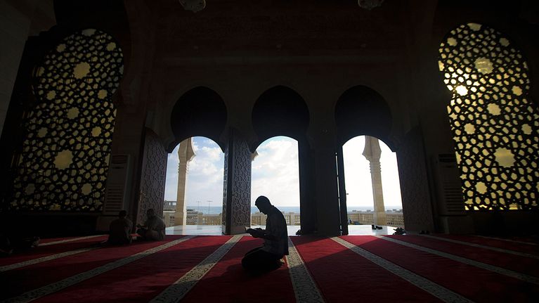 Palestiinalaismies lukee Koraania muslimien paastokuukauden eli Ramadanin aikana moskeijassa.